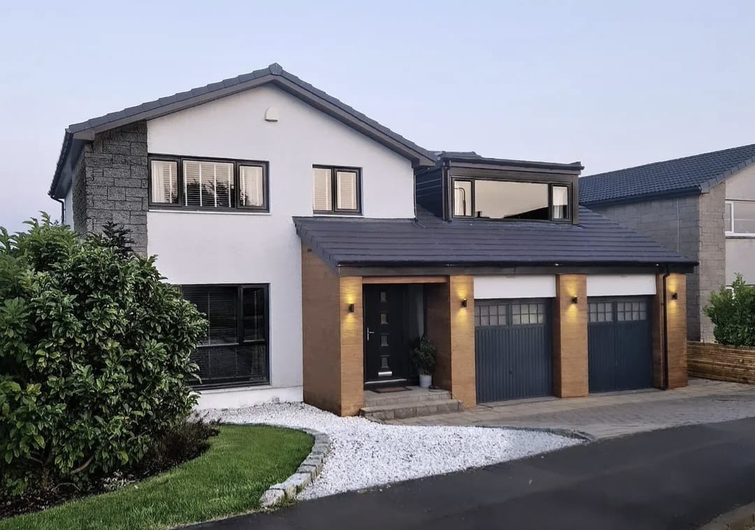 Modern detached home with sprayed anthracite roof, windows and garage doors