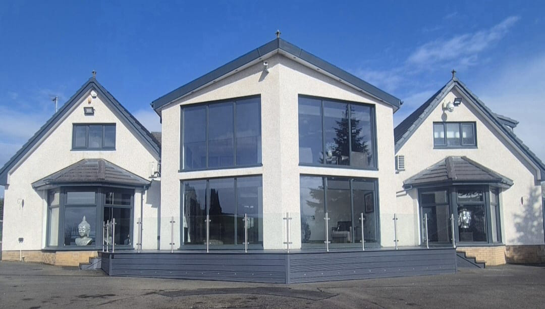 White rendered villa with sprayed anthracite windows and feature gable