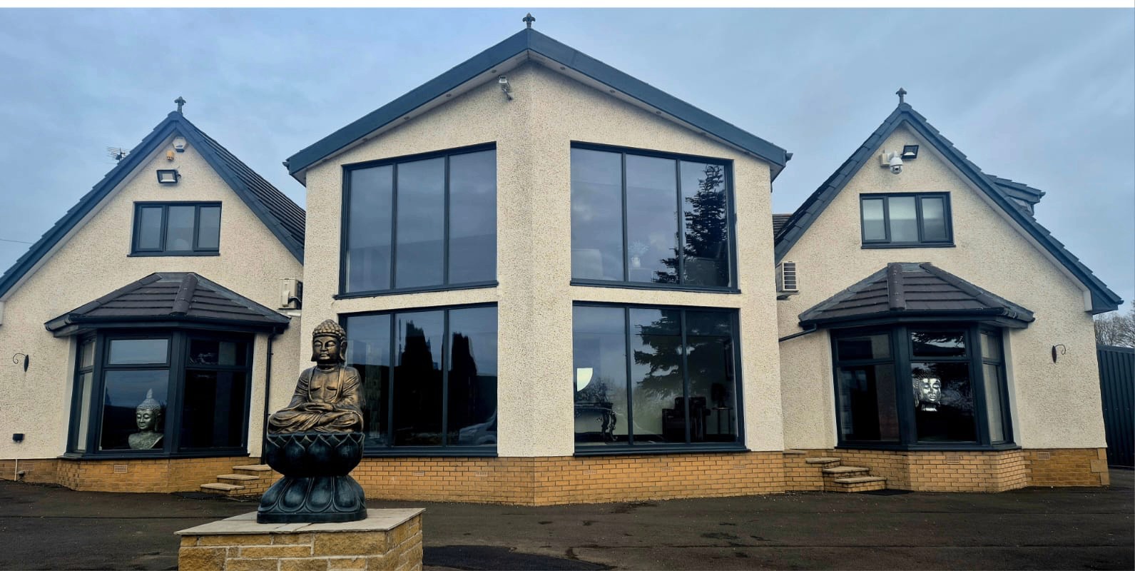 Large residential exterior with sprayed black roofline, windows and trim